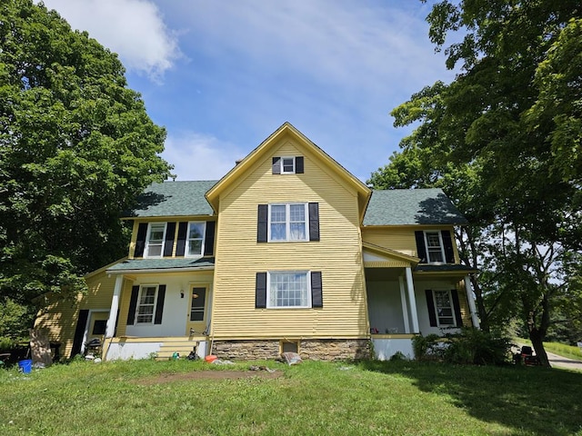 view of front of house with a porch and a front yard