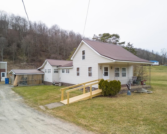view of front of house featuring a front lawn, a porch, and metal roof