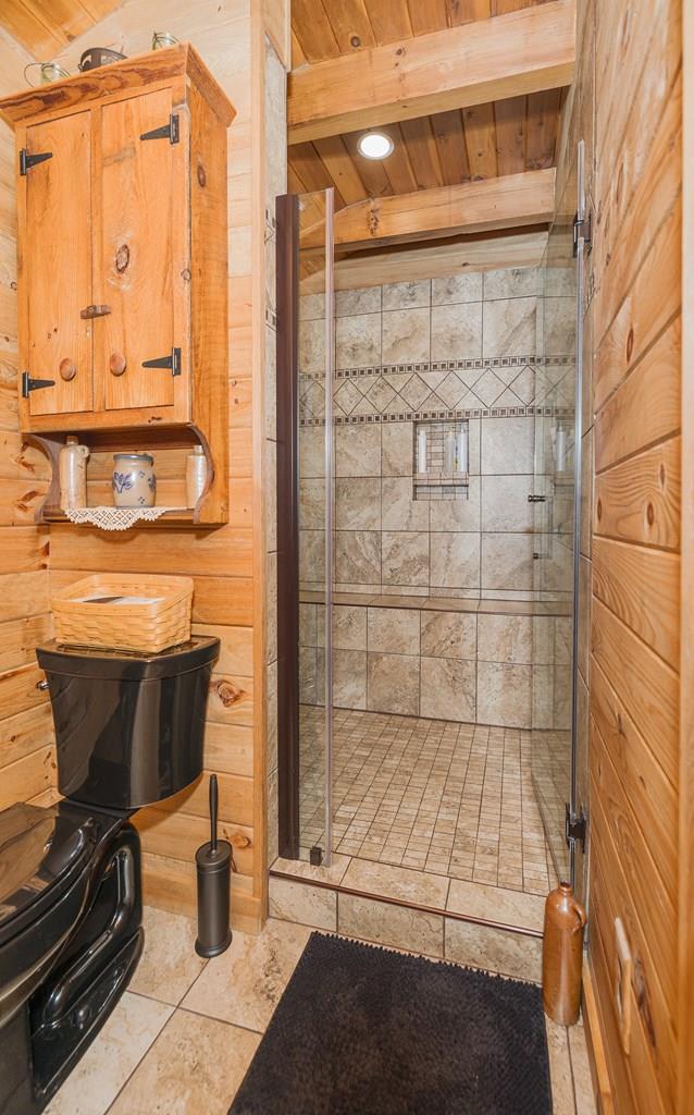 436 Teeter Rd, Genesee, PA 16923 - full bathroom with a stall shower, a wooden ceiling with exposed beams, wooden walls, tile patterned floors, and recessed lighting