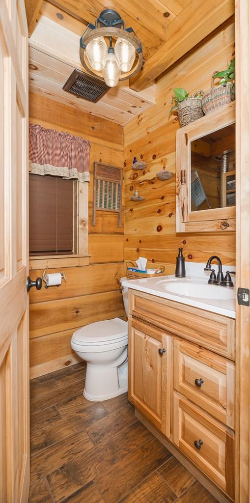 436 Teeter Rd, Genesee, PA 16923 - bathroom featuring vanity, wooden walls, wood finished floors, and wooden ceiling