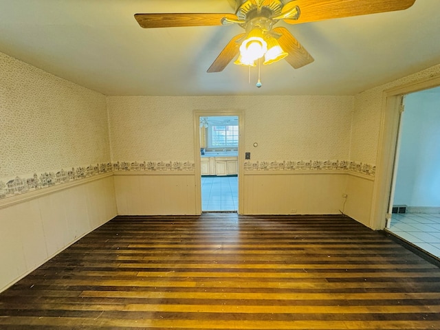 unfurnished room with ceiling fan and dark wood-type flooring