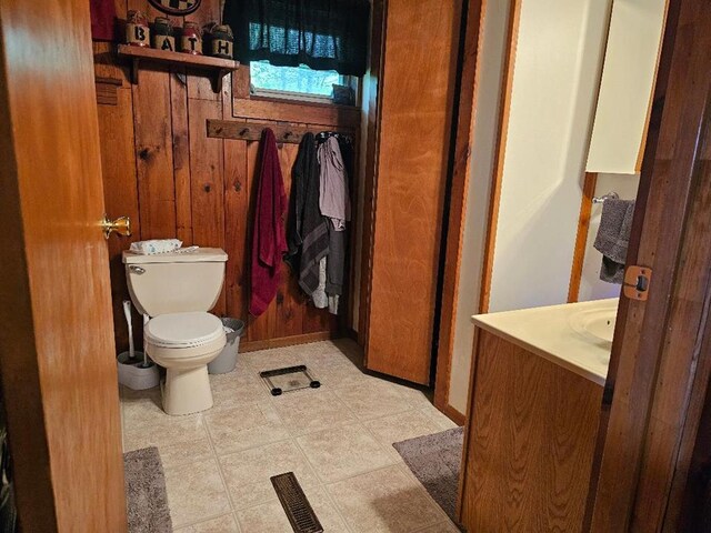 516 Dutch Hill Rd, Coudersport, PA 16915 - bathroom featuring vanity, toilet, and wood walls