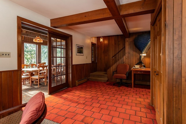 sitting room with beam ceiling, french doors, baseboard heating, and wood walls