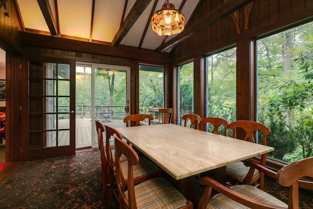 sunroom / solarium featuring vaulted ceiling with beams