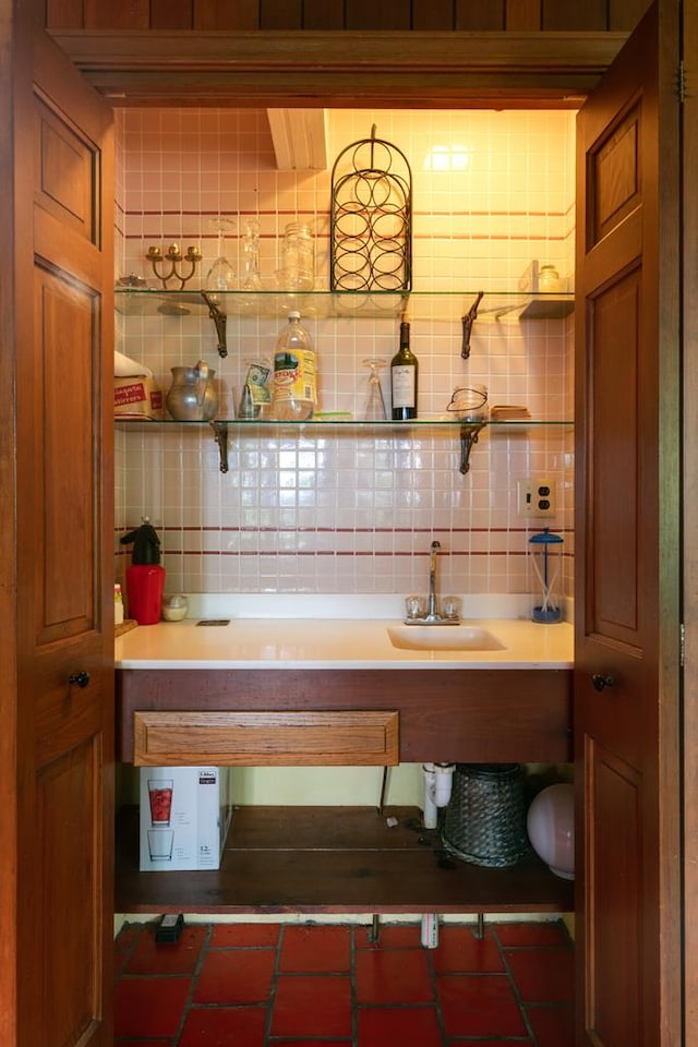 bar with decorative backsplash and a sink