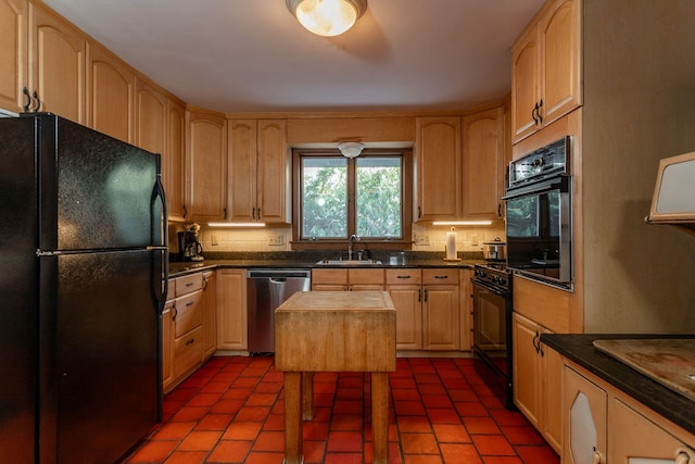 kitchen with tasteful backsplash, light brown cabinetry, butcher block counters, black appliances, and a sink