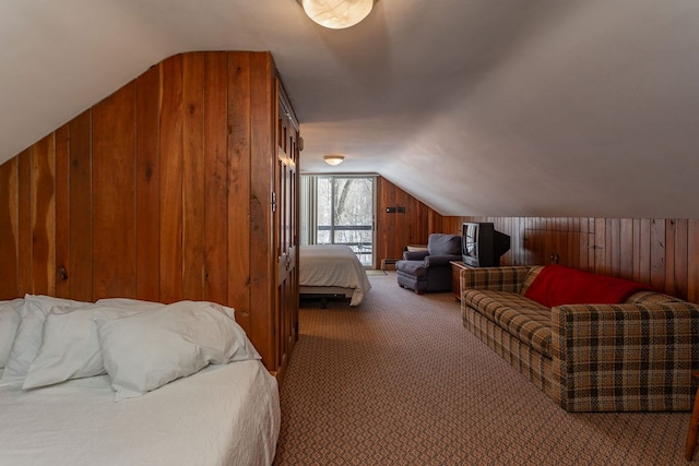 bedroom with wooden walls, lofted ceiling, and carpet