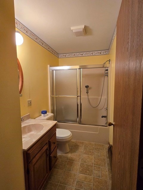 full bathroom with shower / bath combination with glass door, vanity, and toilet