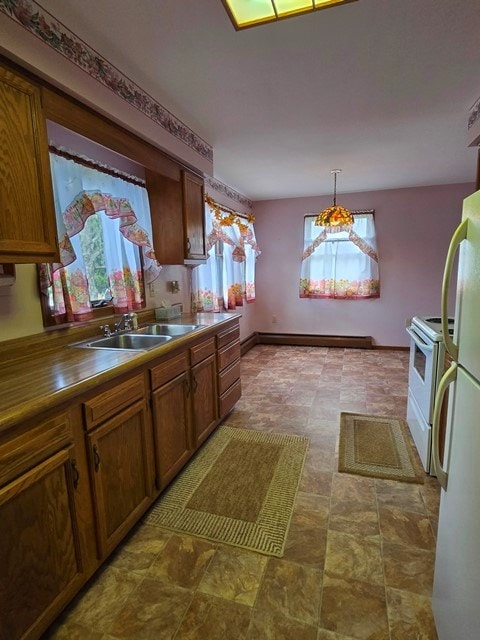 kitchen featuring pendant lighting, white appliances, and sink