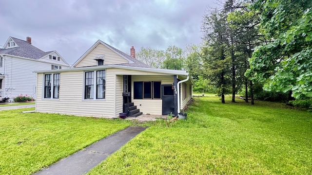 128 Bradford St, Sayre, PA 18840 - view of front facade featuring a front yard, a chimney, and entry steps