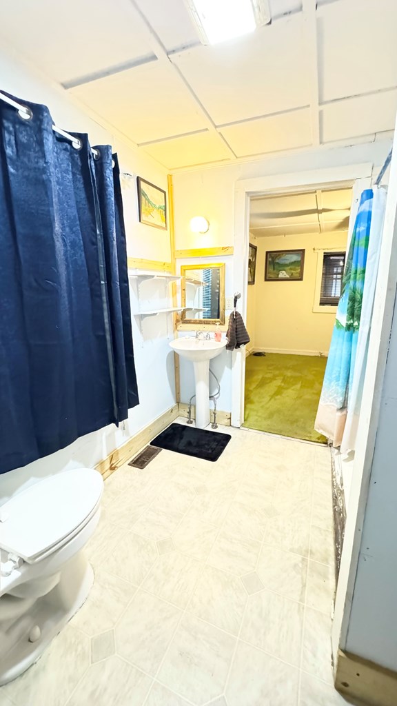 128 Bradford St, Sayre, PA 18840 - bathroom featuring a shower with shower curtain and toilet