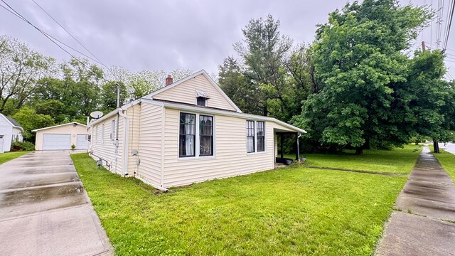 128 Bradford St, Sayre, PA 18840 - view of home's exterior with a detached garage, an outbuilding, a lawn, and a chimney