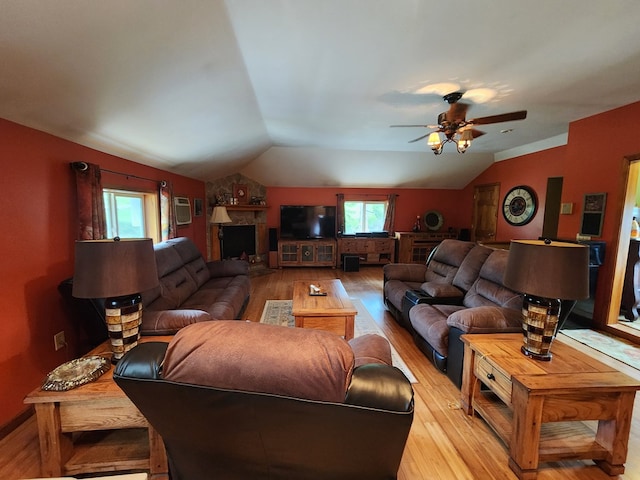 living room featuring ceiling fan, light wood-type flooring, and lofted ceiling