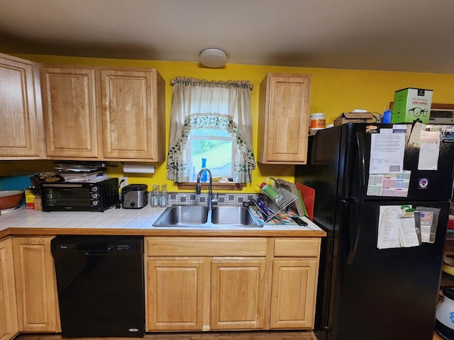 kitchen with light brown cabinetry, tile counters, sink, and black appliances