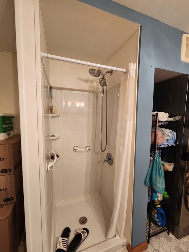 bathroom with a shower with shower curtain and tile patterned flooring