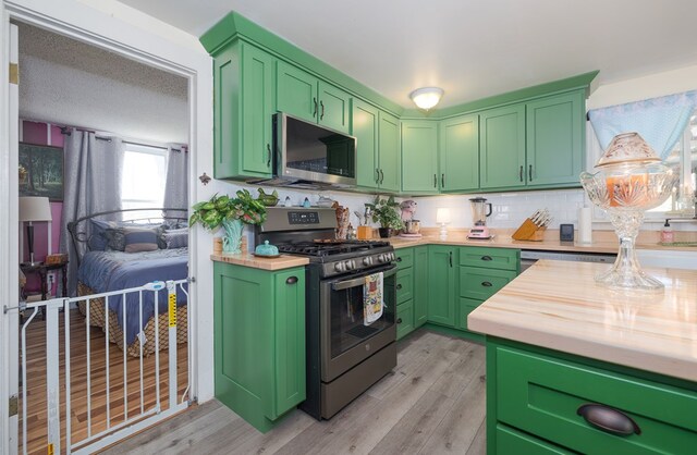1503 Stewart Rd, Addison, NY 14801 - kitchen with stainless steel appliances, butcher block countertops, light wood-type flooring, and backsplash