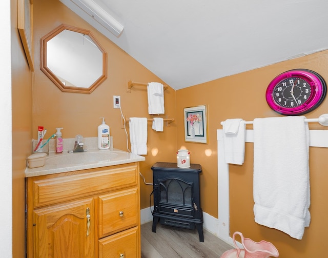 1503 Stewart Rd, Addison, NY 14801 - bathroom featuring a wood stove, vaulted ceiling, wood finished floors, and vanity