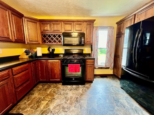 kitchen with a textured ceiling and black appliances