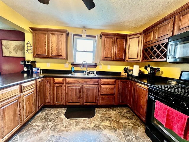 kitchen featuring black gas range, ceiling fan, sink, and a textured ceiling