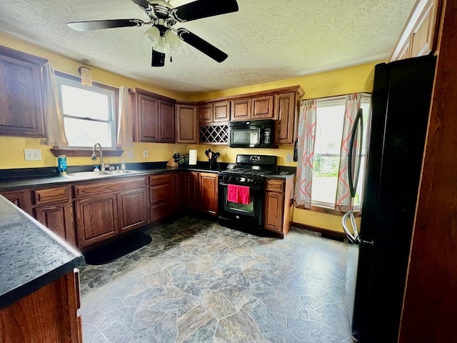 kitchen featuring sink, ceiling fan, a healthy amount of sunlight, and black appliances