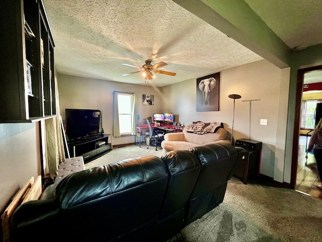 carpeted living room with ceiling fan and a textured ceiling