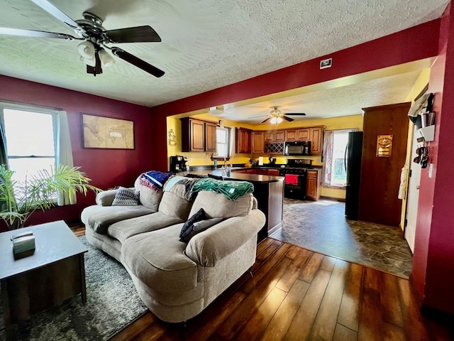 living room featuring ceiling fan, dark hardwood / wood-style flooring, and a textured ceiling