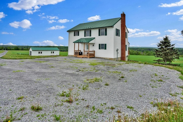 667 Ostrom Hill Rd, Liberty, PA 16930 - rear view of house with a chimney, metal roof, a wooden deck, and driveway