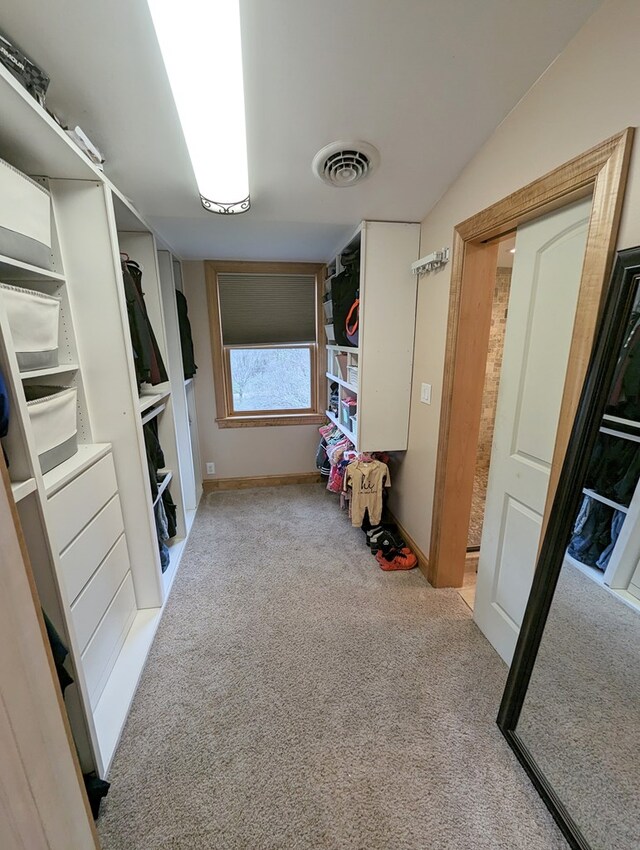 walk in closet featuring light carpet