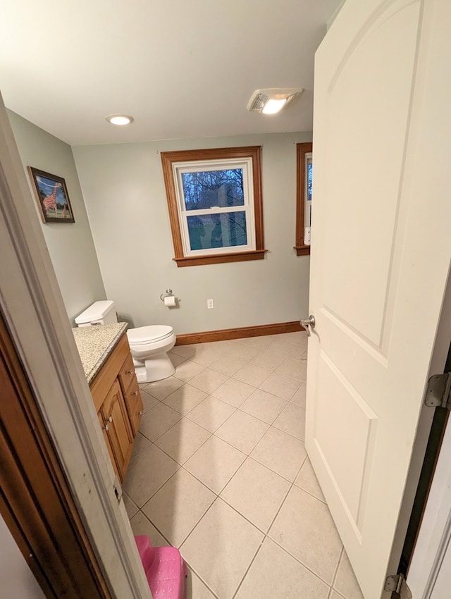 bathroom with toilet, vanity, and tile patterned floors