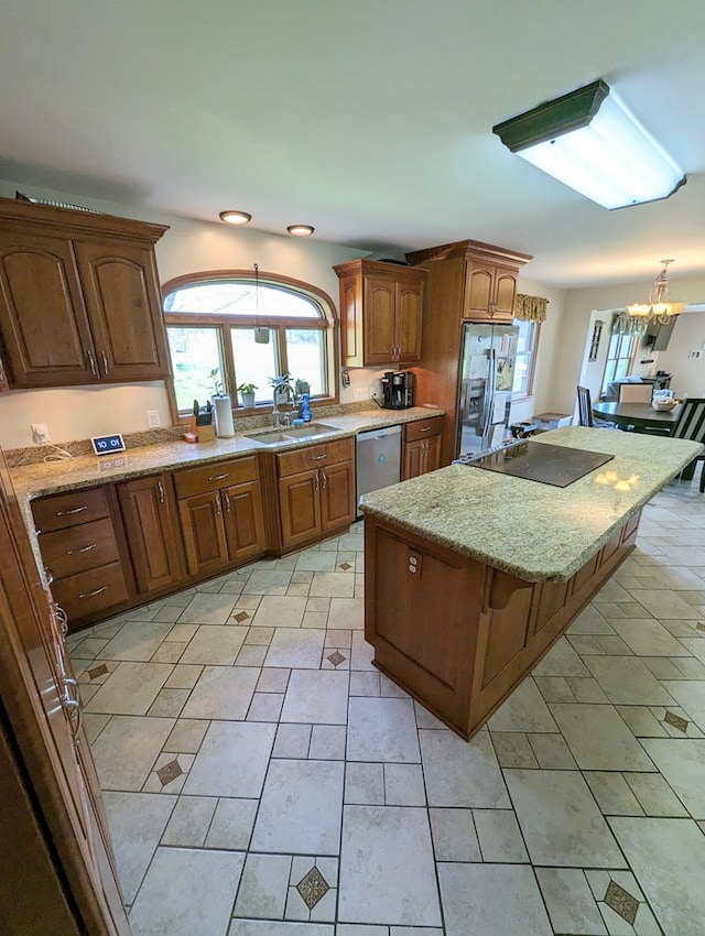 kitchen featuring pendant lighting, a center island, an inviting chandelier, sink, and appliances with stainless steel finishes