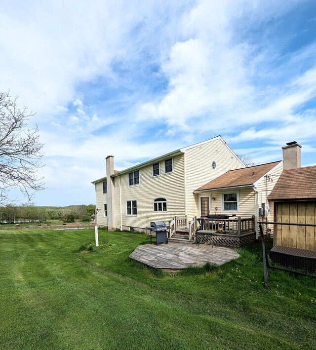 back of property featuring a yard, a patio, and a deck