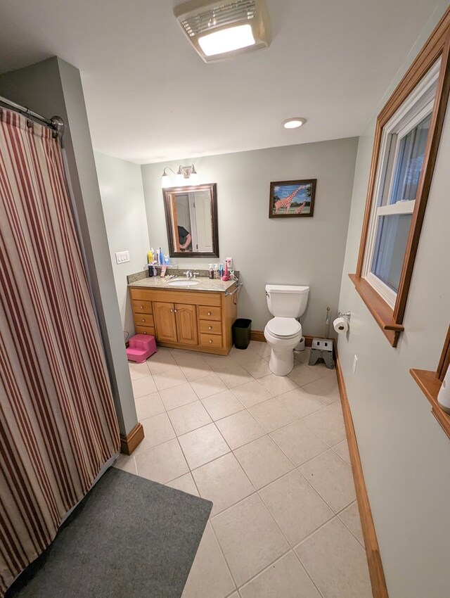 bathroom with toilet, vanity, and tile patterned floors