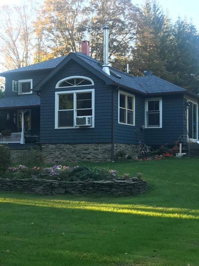 view of property exterior with a yard, a chimney, and a shingled roof