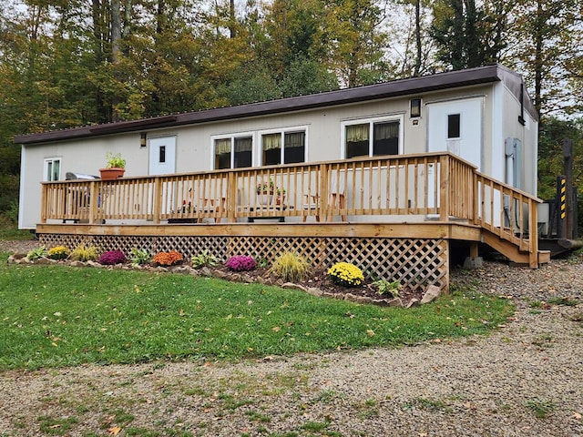 rear view of house with a lawn and a deck