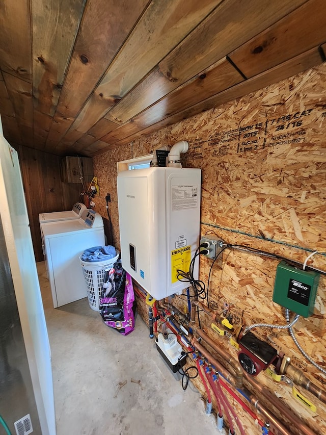 interior space featuring water heater, wood walls, and washer / dryer