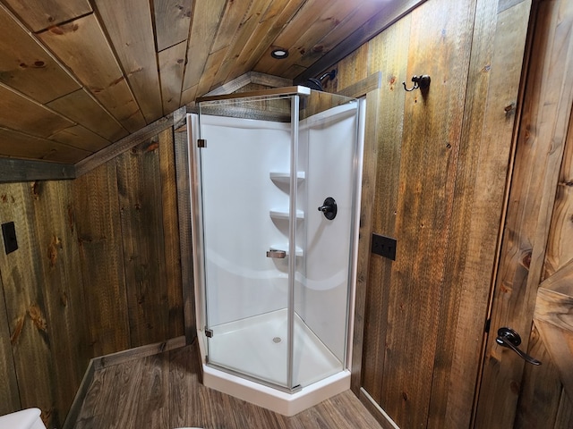 bathroom featuring wooden ceiling, wood-type flooring, vaulted ceiling, an enclosed shower, and wooden walls