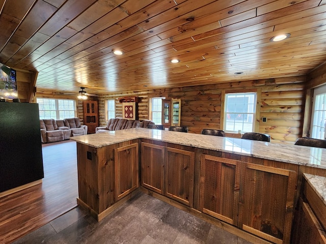 kitchen with light stone countertops, wood ceiling, kitchen peninsula, and log walls