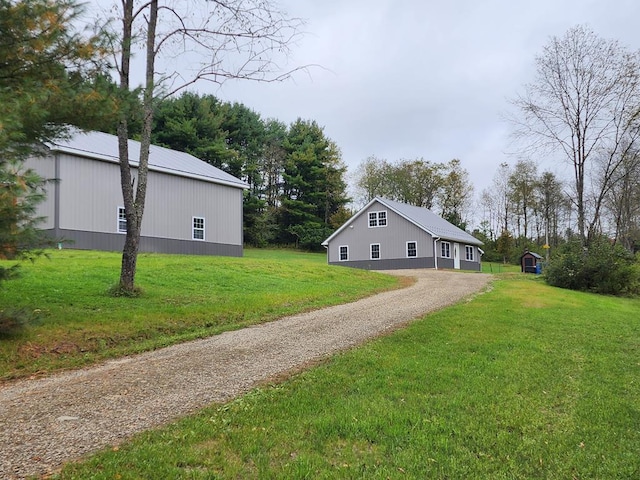 view of side of property featuring a lawn and an outdoor structure