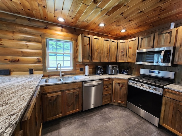 kitchen with sink, rustic walls, light stone counters, wood ceiling, and stainless steel appliances