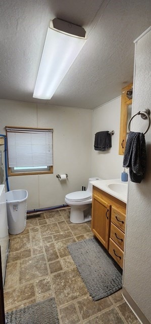 bathroom with vanity, a textured ceiling, and toilet