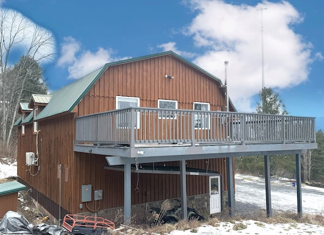 snow covered house featuring a deck