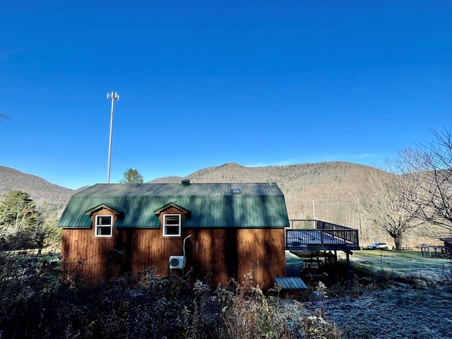 view of side of home with a deck with mountain view