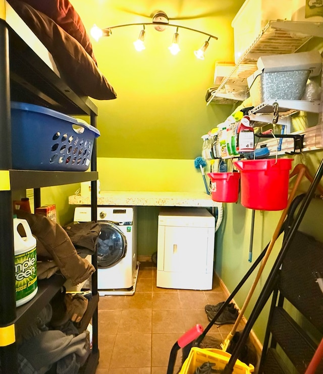 laundry area with separate washer and dryer and light tile patterned floors