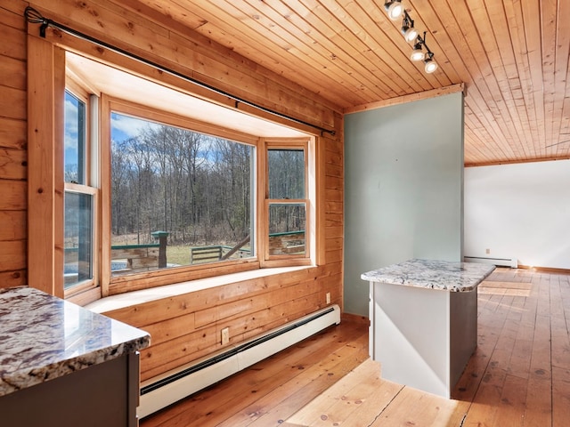 kitchen featuring baseboard heating, wood walls, wooden ceiling, and hardwood / wood-style floors