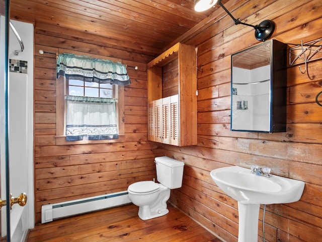 bathroom with toilet, wood-type flooring, wooden walls, wooden ceiling, and a baseboard radiator