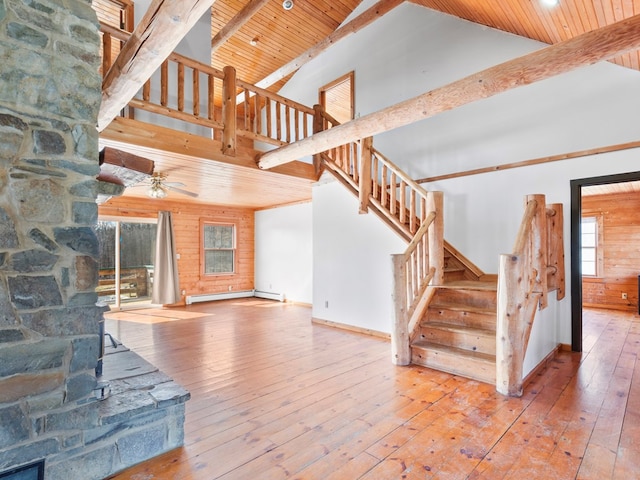 staircase with beam ceiling, high vaulted ceiling, wood-type flooring, wood walls, and wooden ceiling