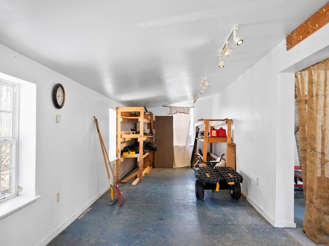 interior space featuring a wealth of natural light, concrete floors, and baseboards