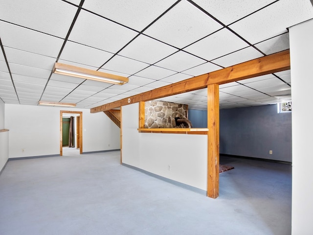 below grade area featuring baseboards and a paneled ceiling