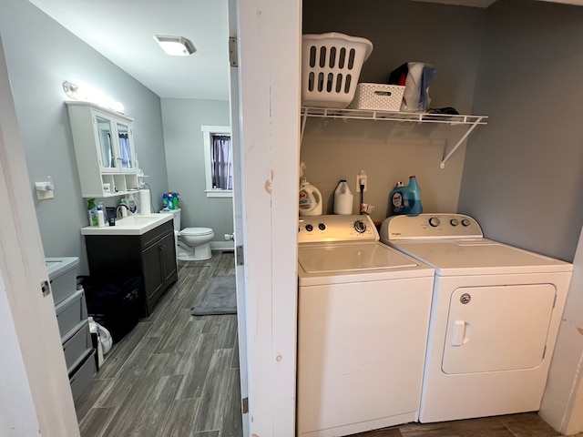 laundry room with dark hardwood / wood-style floors, separate washer and dryer, and sink