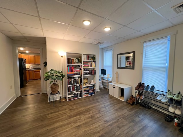 miscellaneous room with a paneled ceiling and dark hardwood / wood-style flooring